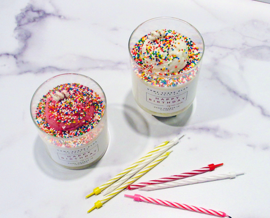 Happy Birthday Candle with ice cream scoop design and colorful sprinkles in glass jar with birthday candles on marble surface