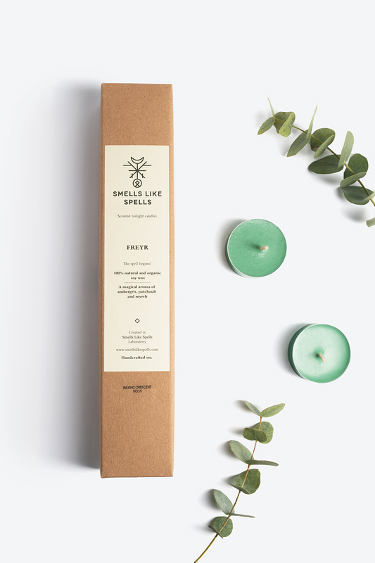 Scented tealight candles FREYR with patchouli, ambergris, and myrrh aromas in eco-friendly packaging with eucalyptus leaves.