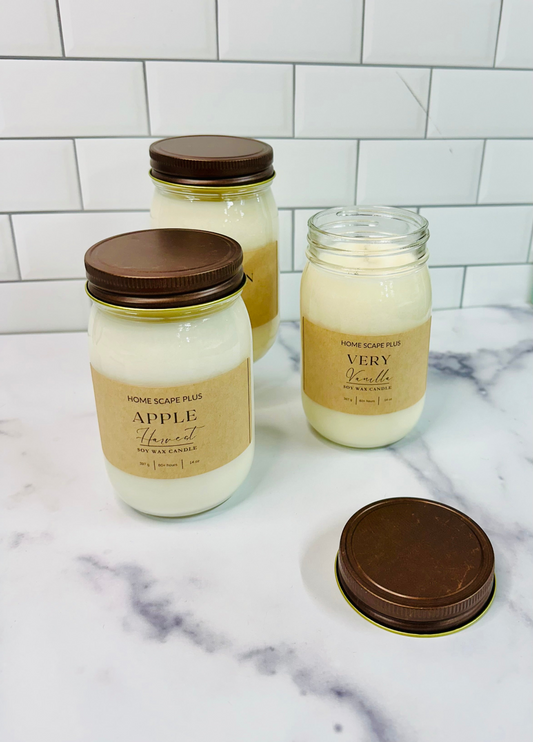 Home Scape Candles soy wax jars with rose gold lids in apple harvest and vanilla scents on marble surface