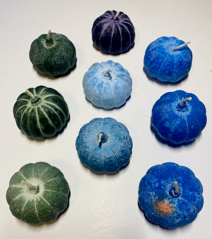 Handmade cool color pumpkin soy candles in blue, green, and purple shades with seasonal essential oil scent.