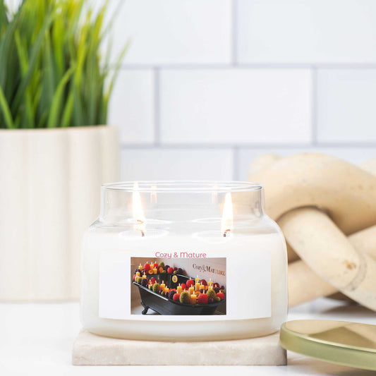 Double wick apothecary jar candle with natural soy wax and gold lid, burning on a marble surface.